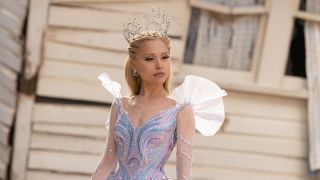 Ariana Grande as Glinda standing in front of destroyed white house in Wicked For Good