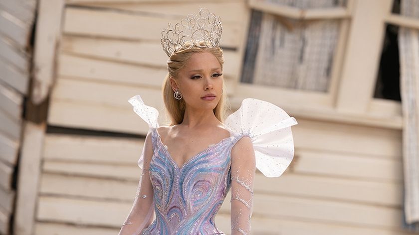 Ariana Grande as Glinda standing in front of destroyed white house in Wicked For Good