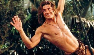 Brendan Fraser swings on a vine and smiling in George Of The Jungle.