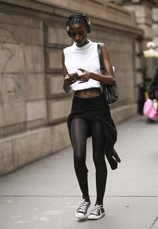 woman wearing mock neck, leggings, and converse sneakers