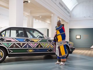 Esther Mahlangu and brightly coloured BMW art car in white gallery space
