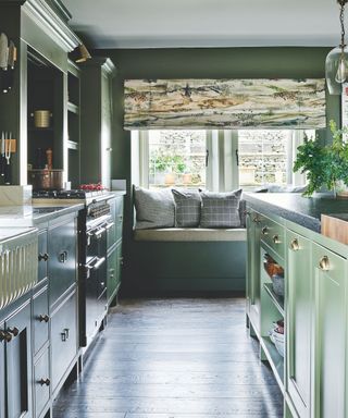 Traditional green kitchen with island and window seat