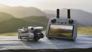 DJI Mini 4 Pro folded away and next to the R2 Remote Controller, on a rock
