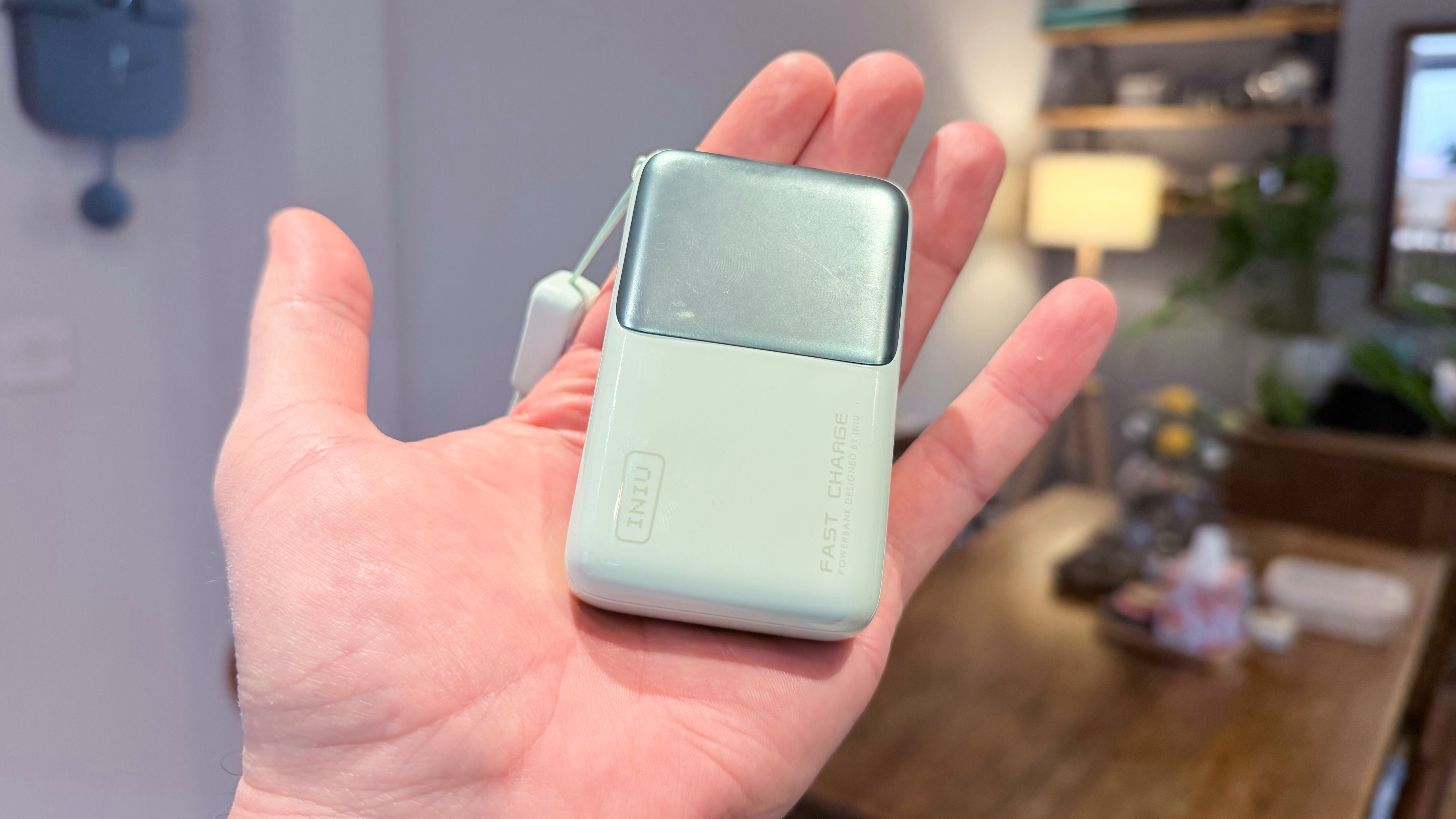 A sage green Iniu Mini Power Bank in hand.