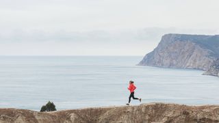 Person running along a cliff by the sea