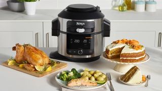 A Ninja food processor with a selection of prepared dishes sitting around it on the kitchen counter