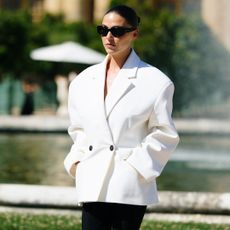 A paris fashion week attending wearing sunglasses and white oversized blazer