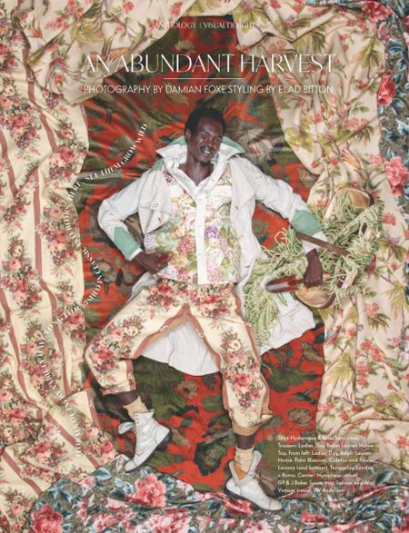A male black model wearing and surrounded by swathes of fabrics in florals, carrying garden tools. A magazine front cover for Anthology