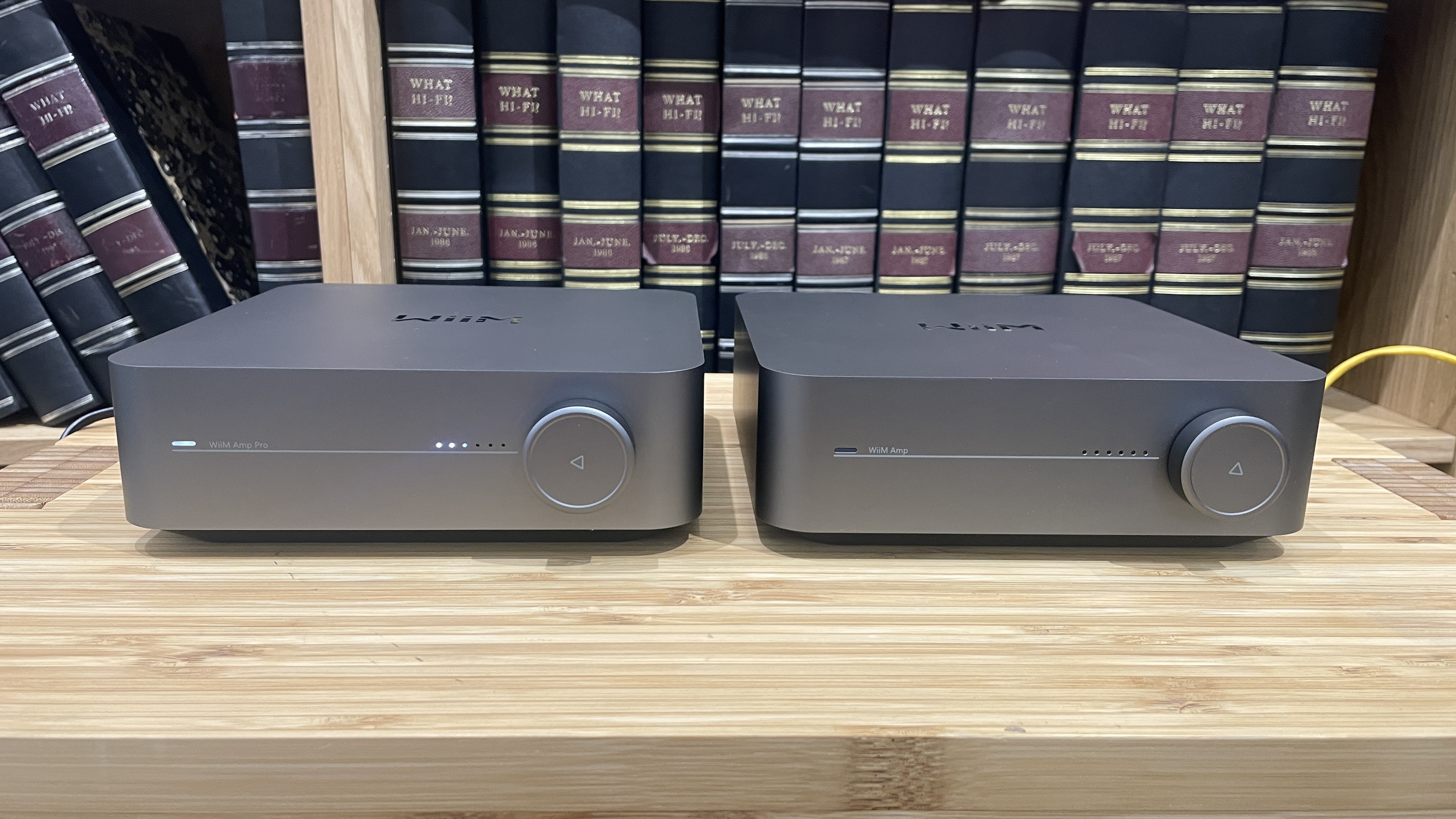 WiiM Amp Pro and WiiM Amp both placed side-by-side on a wooden rack