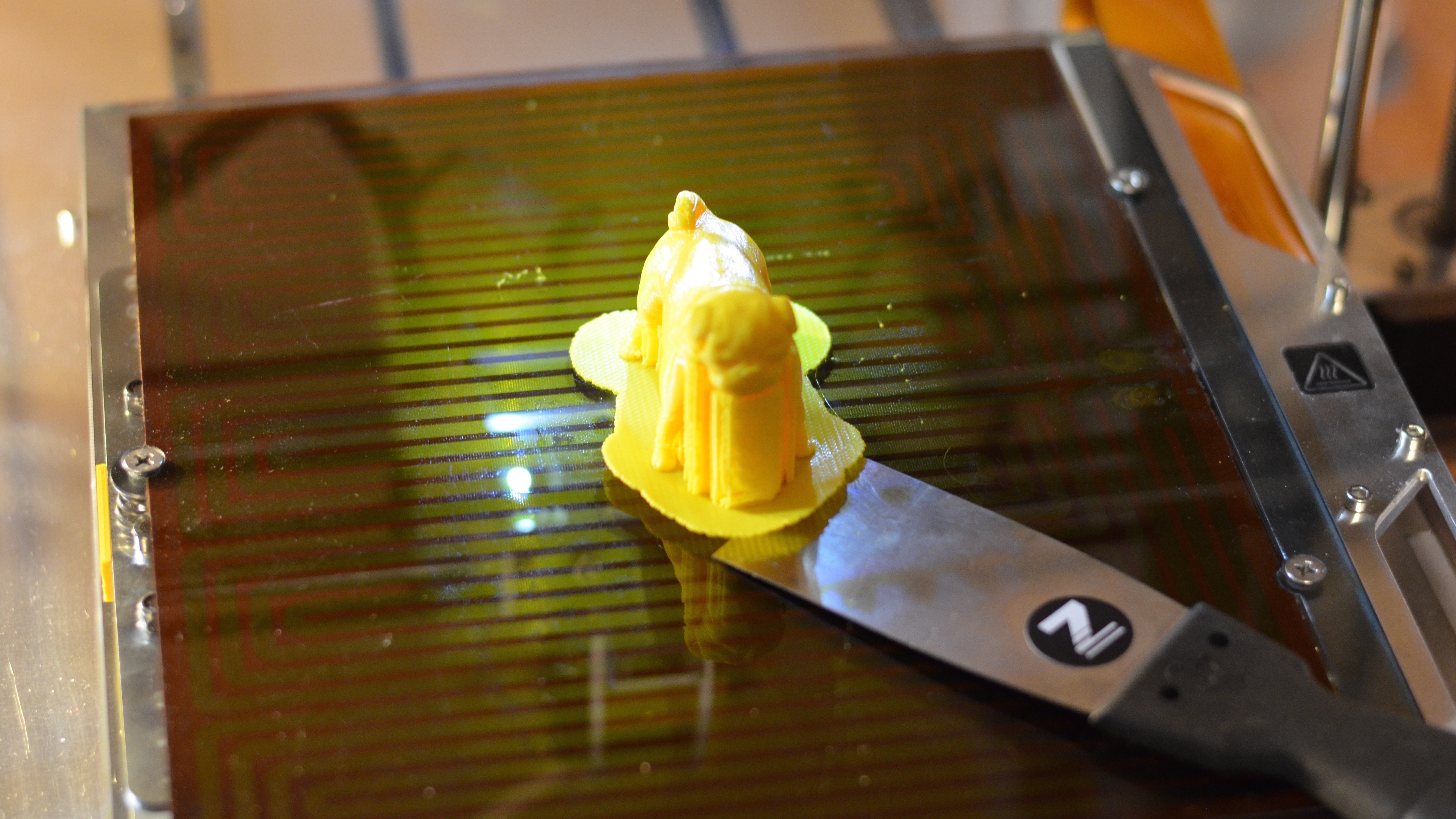 Removing a 3D print of a pug on the ZMorph. The supports under its chin and body simply snap off.