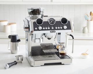 A silver De'Longhi La Specialista Maestro espresso machine in a white kitchen