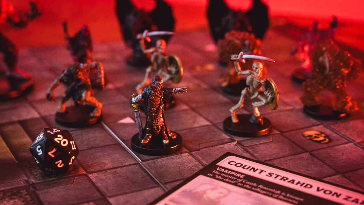 Castle Ravenloft board game components laid out on a dark table, with an ominous red glow on them