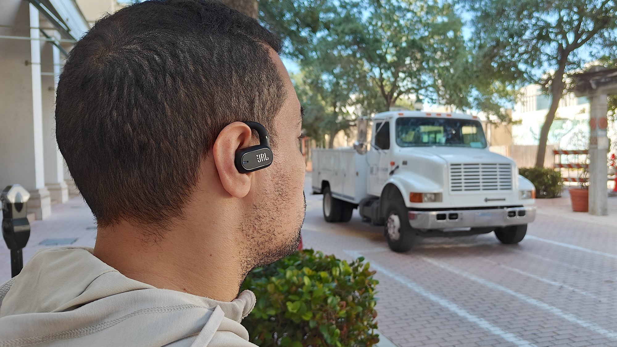 JBL Soundgear Sense worn by reviewer Alex Bracetti in a high street setting