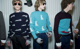 Three male models wearing clothing by Prada in blue shades.
