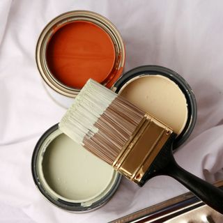 Three paint pots with paint brush