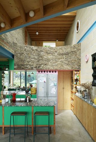 Colourful kitchen with green cupboards and granite tops at Forest House
