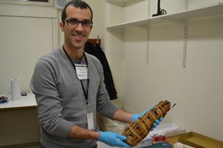 Study lead researcher Claudio Ottoni, a paleogeneticist Leuven University in Belgium, examines a cat mummy at the National History Museum in London. The researchers were unable to analyze the DNA of this particular mummy because wrapped mummies cannot be sampled. Rather, they got samples from deteriorated mummies.