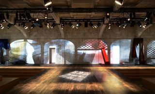 Room with wooden floor boards and projected images on walls