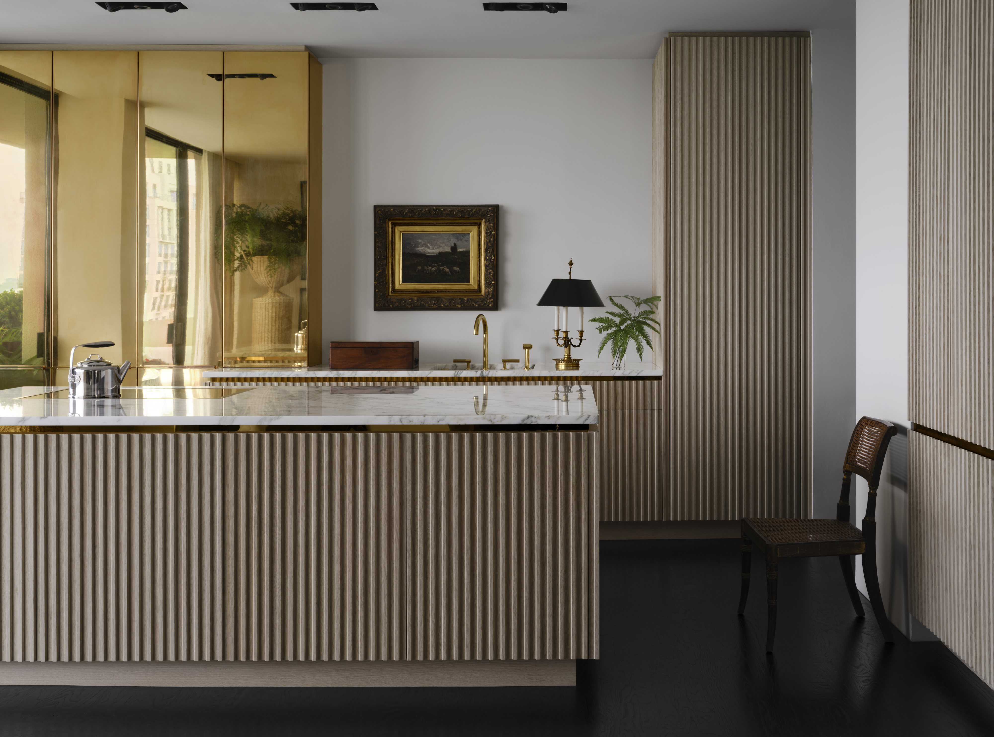 A kitchen with a large island, designed with fluted finishes