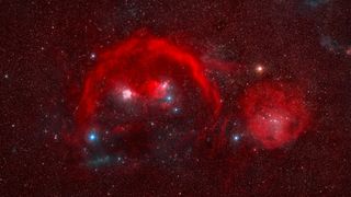 a red cloud of gas seen among thousands of background stars