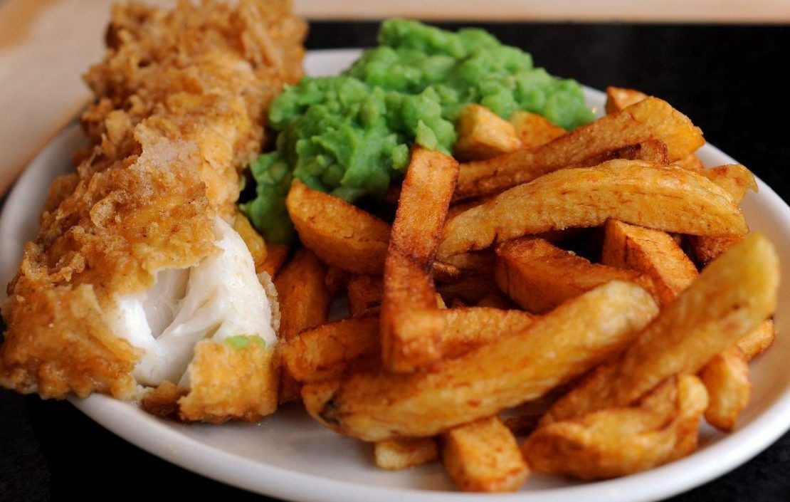 A plate of fish chips and mushy peas