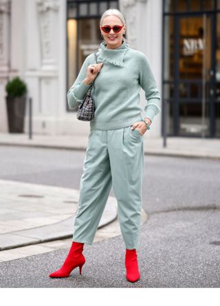 Petra van Bremen in a teal outfit with bright red boots