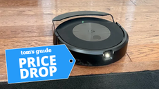 iRobot Roomba Combo j9+ on hardwood floor about to approach rug with Price Drop badge