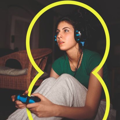 A woman playing a video game with a headset on in a dark room