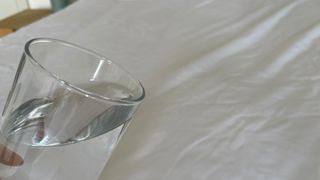 A glass of water being poured over Soak & Sleep Anti-Bed Bug Mattress Encasement