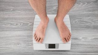 man-standing-on-weight-scale