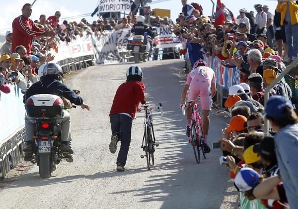 A mechanic runs alongside the pink jersey holder David Arroyo just in case of a flat.