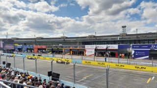 A wide-angle shot of the 2024 Berlin E-Prix, with electric cars on the track.
