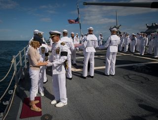 US Navy Captain Steve Shinego, commanding officer of the USS Philippine Sea (CG 58), comforts Carol Armstrong, wife of Neil Armstrong, after she committed Armstrong's cremains to sea during a burial at sea service held onboard the USS Philippine Sea (CG 5
