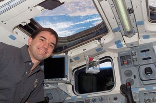 A "Tournament of Roses" rose, seen here with astronaut Rex Walheim, floated in Earth orbit in February 2008 before riding on a float in the 2009 Rose Parade.