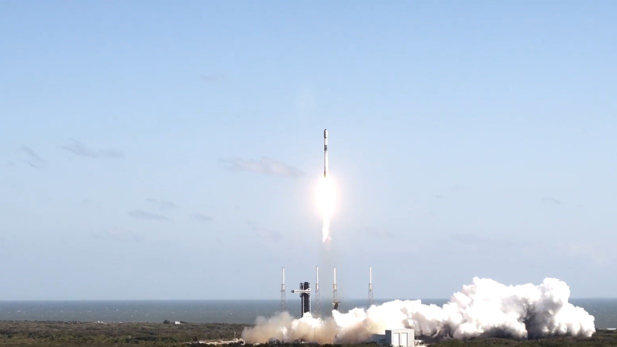 a black and white rocket launches into a blue sky