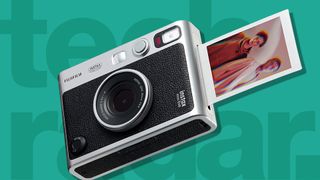 A Fujifilm Instax instant camera on a green background