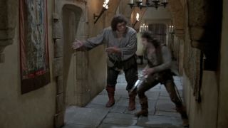 Fezzik gesturing to Inigo to go through the door in The Princess Bride