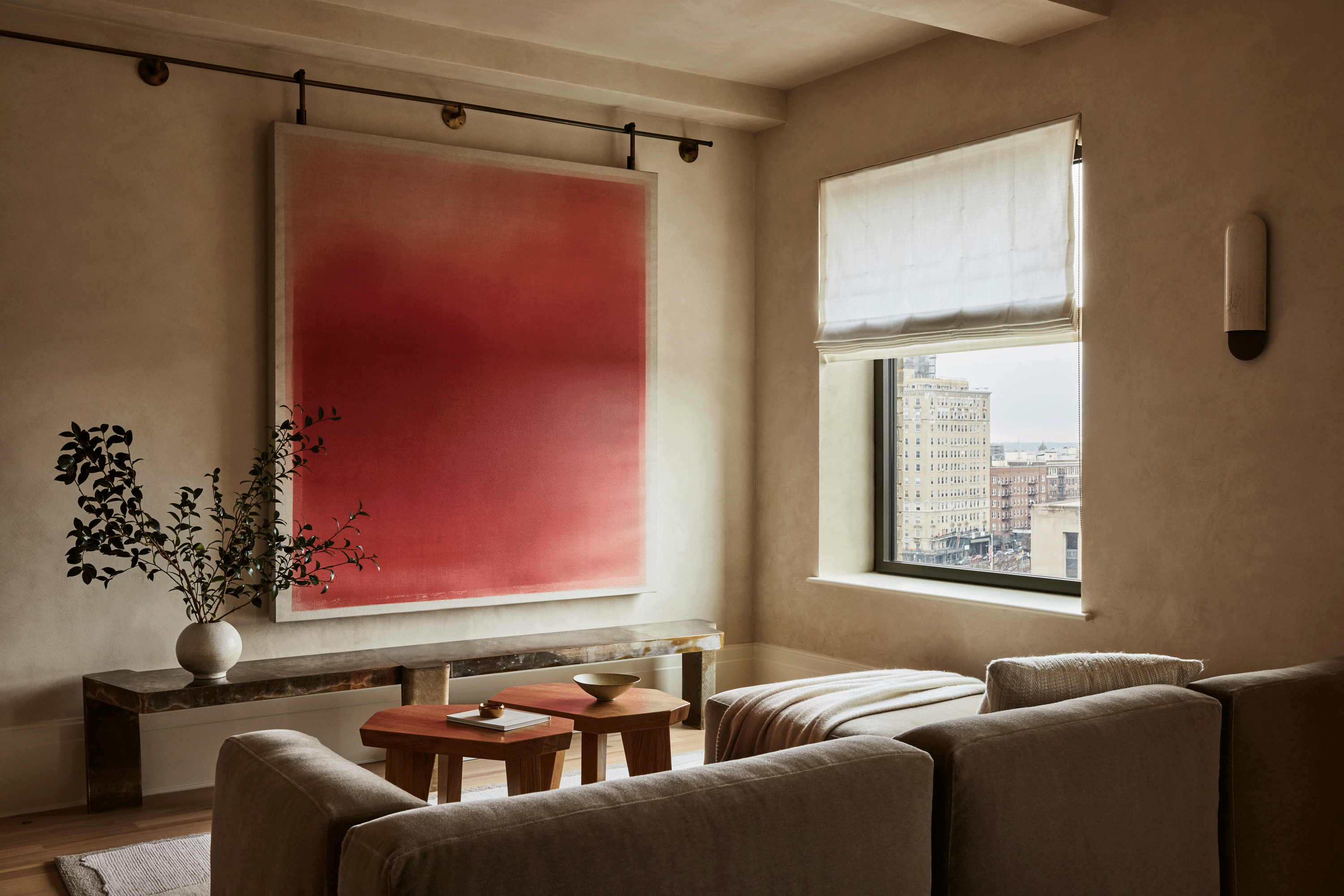 a beige apartment with a red artwork that slides away to reveal a recessed tv