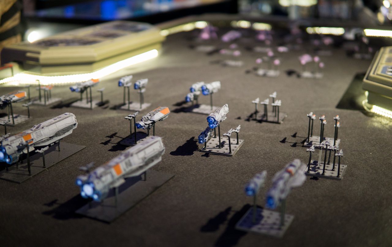A space battle between the Covenant and UNSC playing out in miniature. Halo Wars 2's art director painted ships from the Halo: Fleet Battles tabletop game and laid out the battle the night before the game's launch party. The table was originally a prop used in the short series Halo: Forward Unto Dawn.