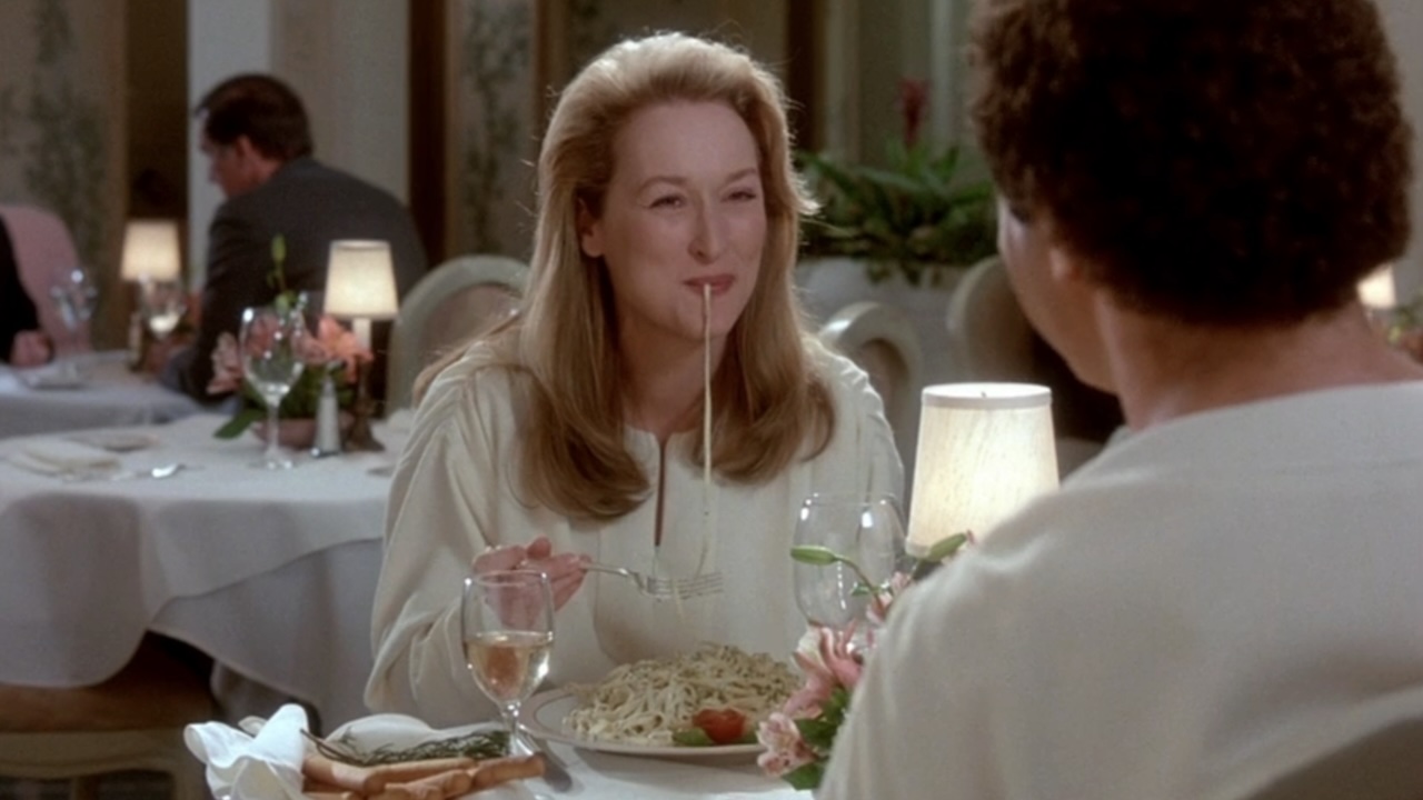 Meryl Streep eating spaghetti and smiling in Defending Your Life
