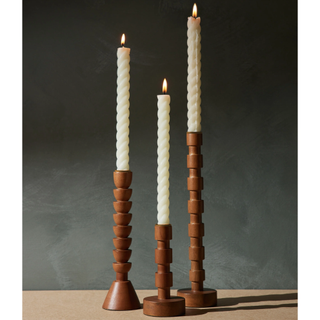wooden candlesticks with different heights and shapes holding tapered candles