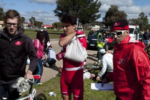Angus Morton (Drapac Porsche) is escorted from the race by his team-manager Agostino Giromondo (right) after biting the bitumen in Robinvale.