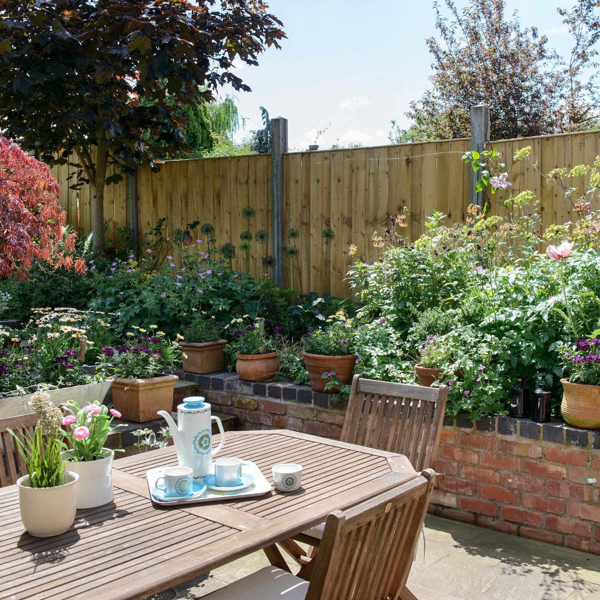 A garden with a wooden privacy screen and a garden furniture set