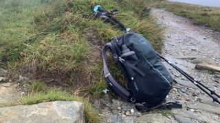 Backpack and trekking poles on a hiking trail