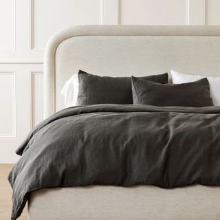 dark gray bedding on beige bed