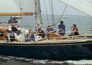 Princess Anne sits next to Anthony, Lord Burghersh, on the yacht Bloodhound at Cowes, Isle of Wight, August 1st 1967. They are sitting against the mast of the yacht, with pullies and rope in background and wire guards in foreground. Lord Burghersh is the son of the Earl of Westmoreland.