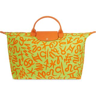 Selfridges Jeremy Scott Zodiac Travel Bag bright green with orange shapes of the zodiac