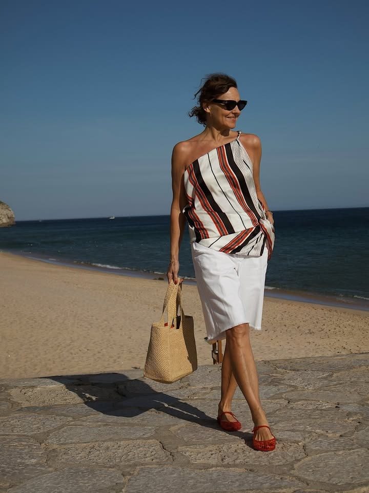 Woman posing in front of the beach.