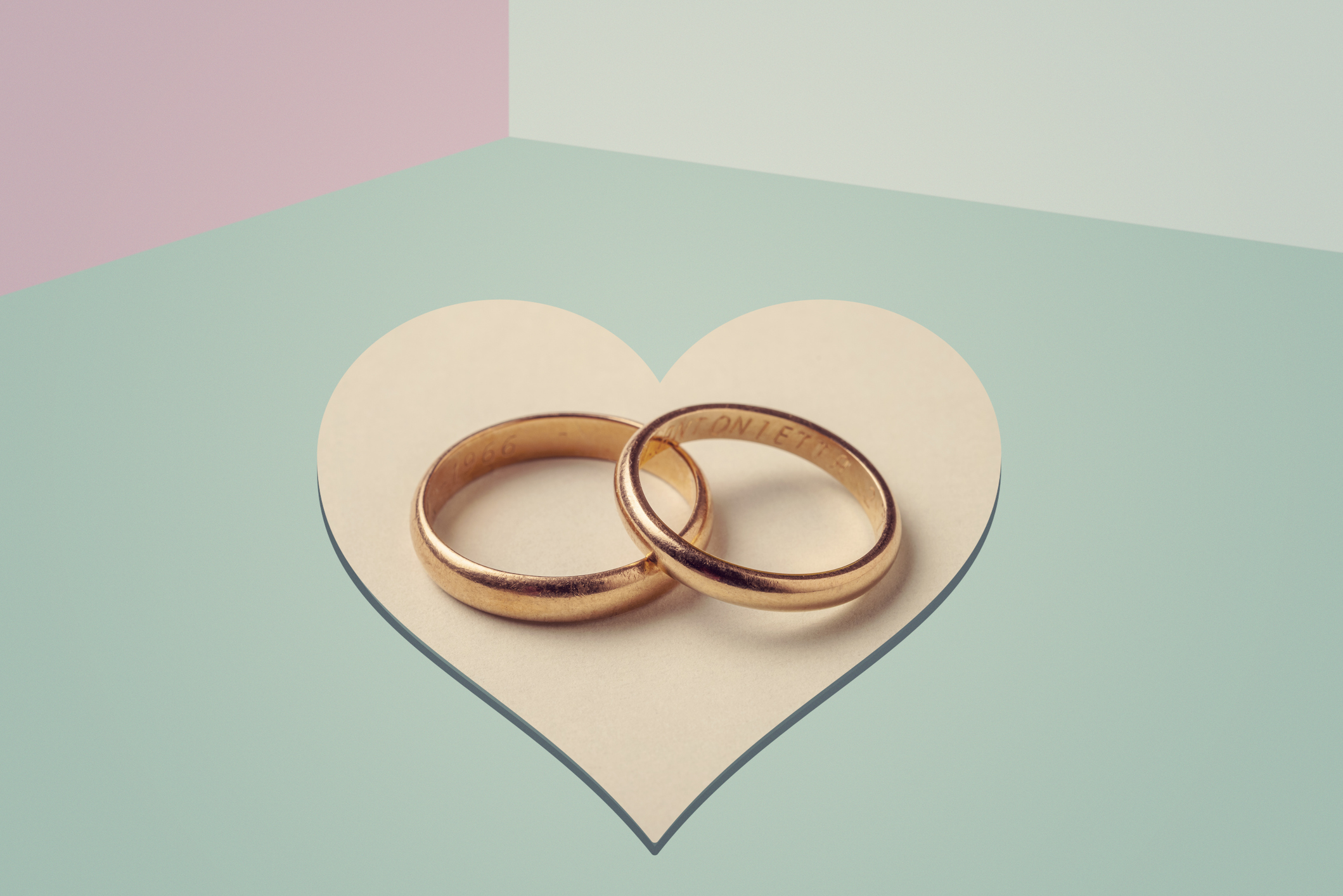 Close-Up Of Wedding Rings on pastel color background