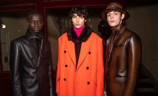 Three male models wearing clothing by Berluti.